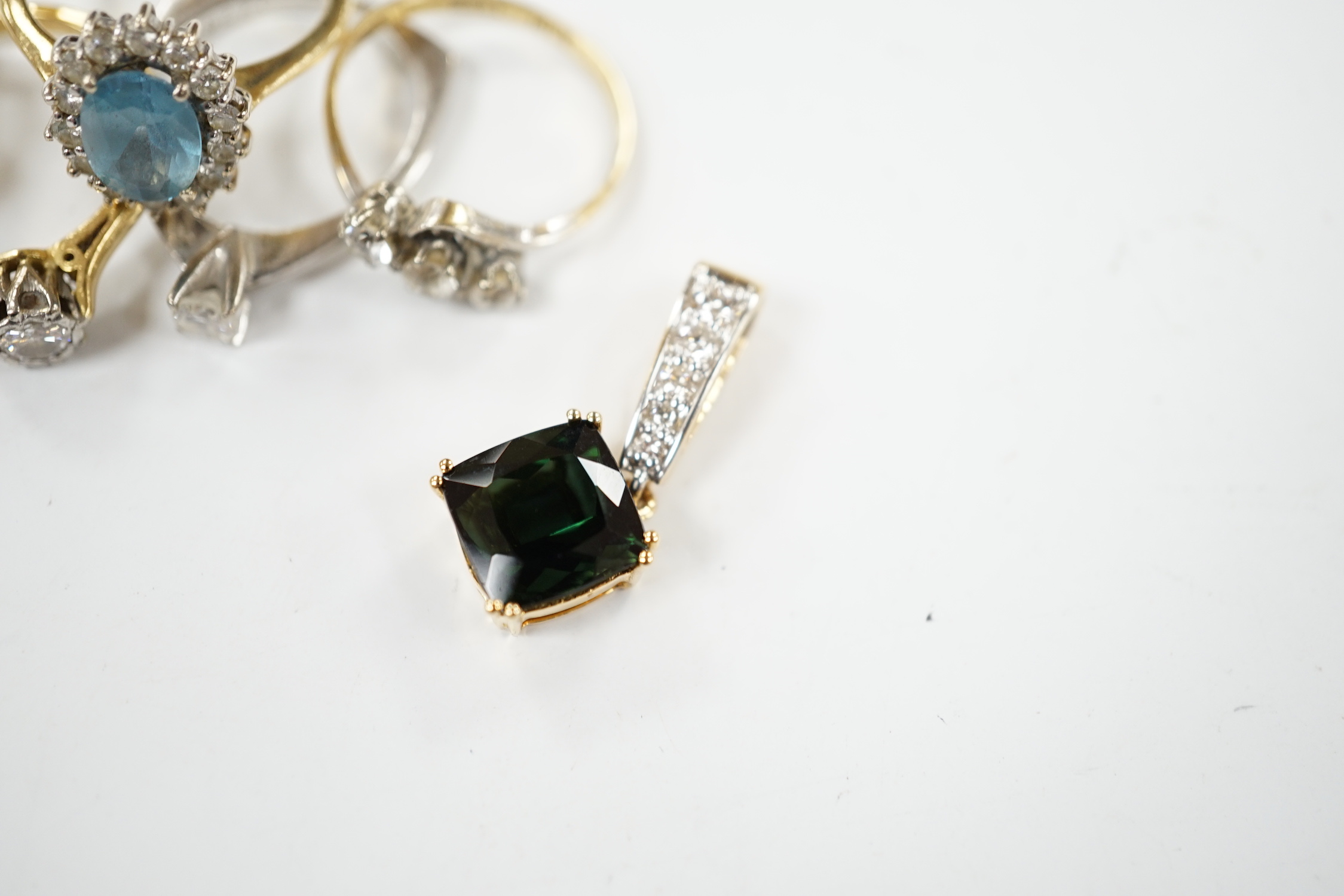 Five assorted modern 18ct and gem set rings, including two solitaire diamond rings and a graduated five stone diamond ring, together with a modern 18ct, green stone and diamond cluster set pendant, gross weight 16 grams.